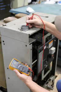 technician uses meter to test circuit breaker